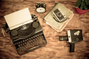 Retro typewriter with paper blank on wood background. Top view